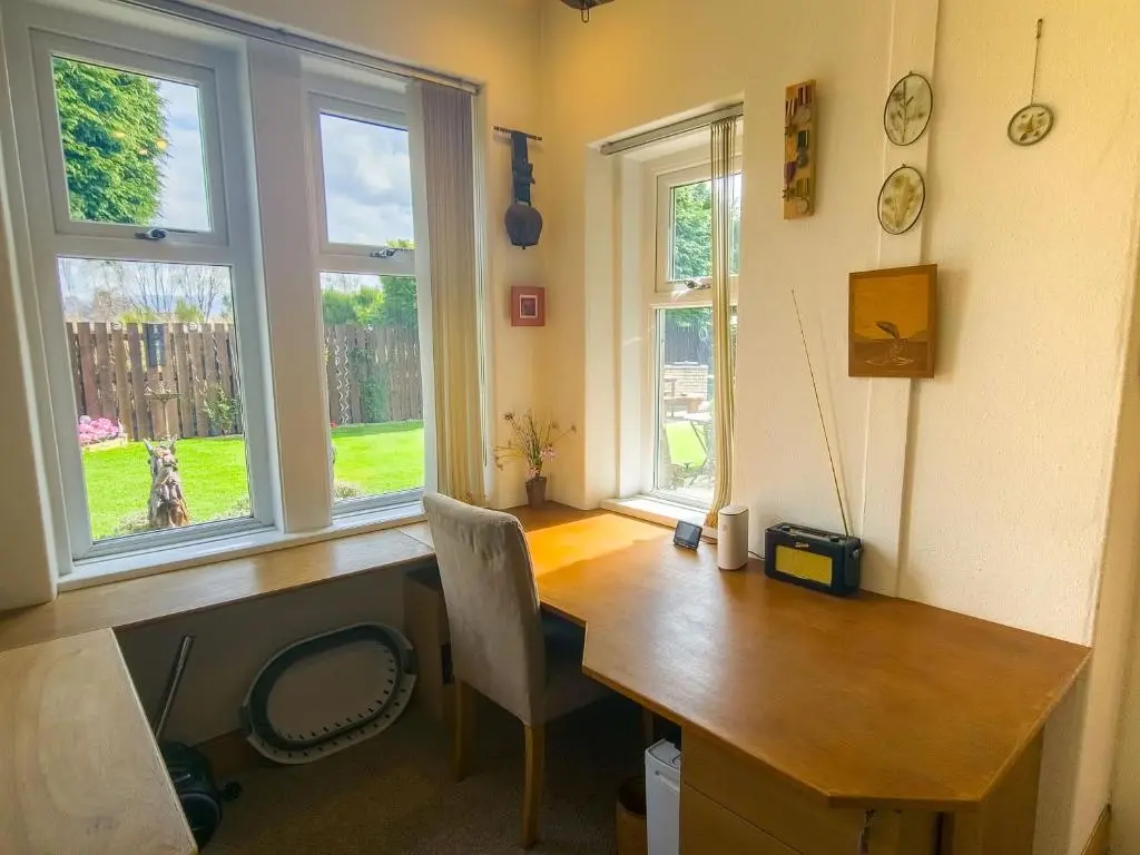 a home office with a wooden desk and two windows at Birchview in Aviemore