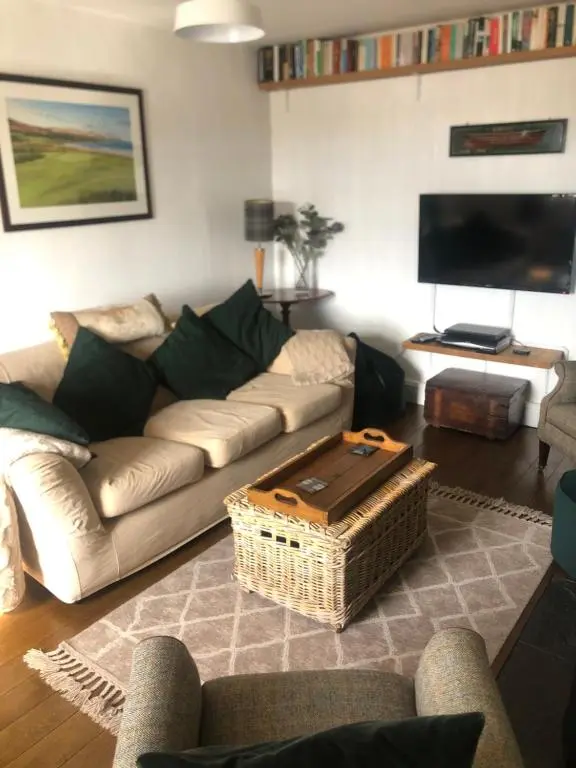 a living room with a couch and a tv at The Hoose in Helmsdale