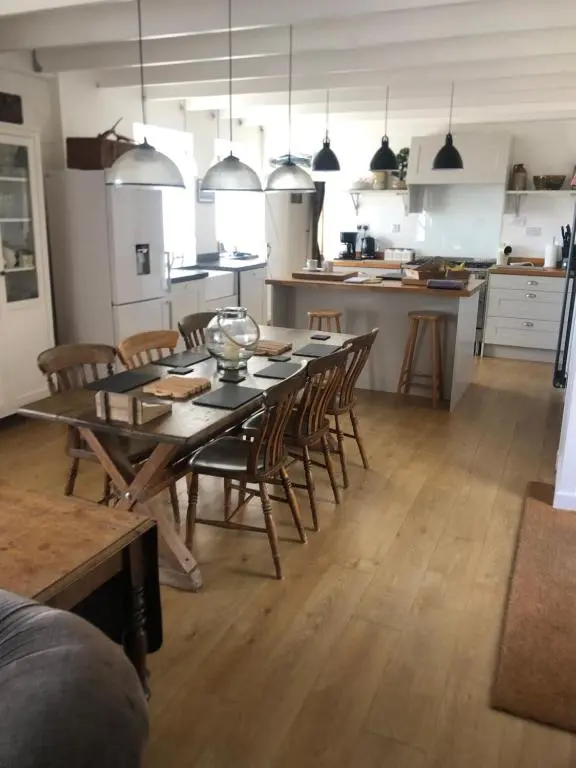 a dining room and kitchen with a table and chairs at The Hoose in Helmsdale