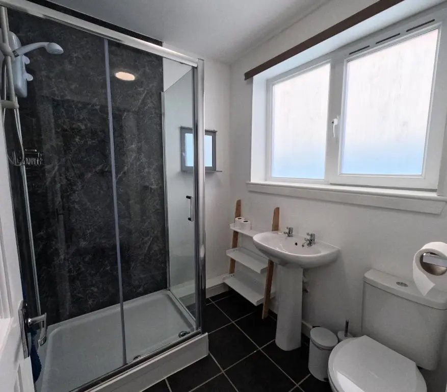 a bathroom with a shower and a toilet and a sink at Rockview Barn in Dufftown