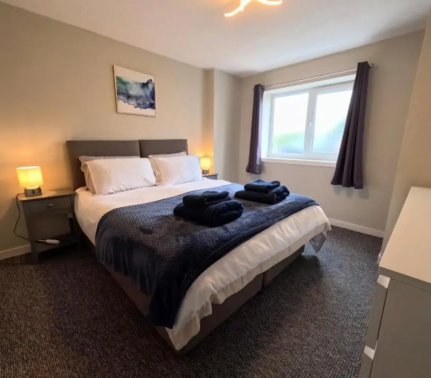 a bedroom with a bed with two towels on it at Rockview Barn in Dufftown
