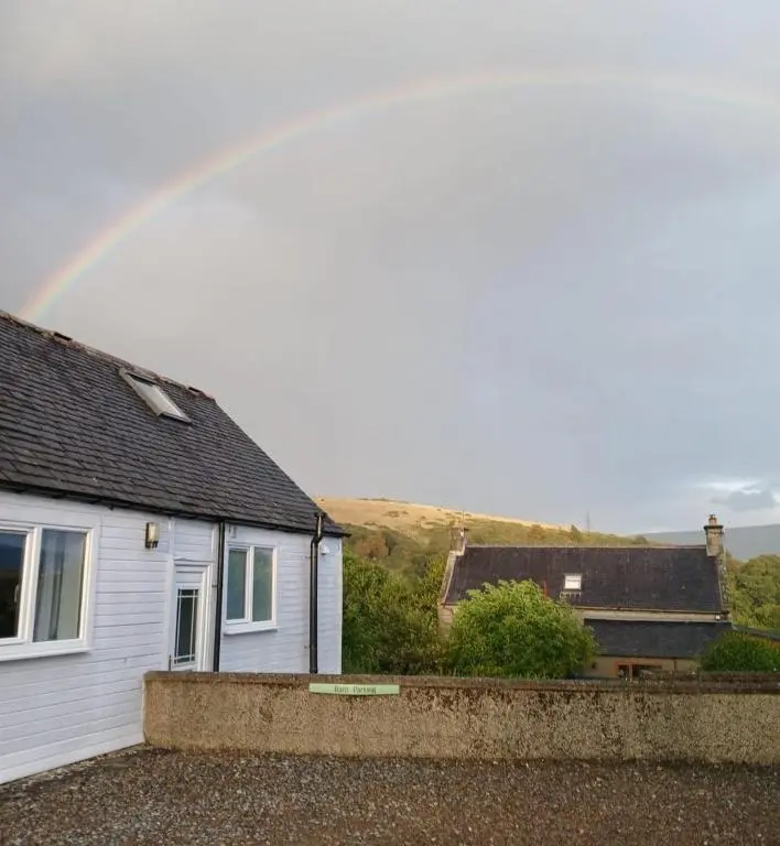 a rainbow over a house with at Rockview Barn in Dufftown