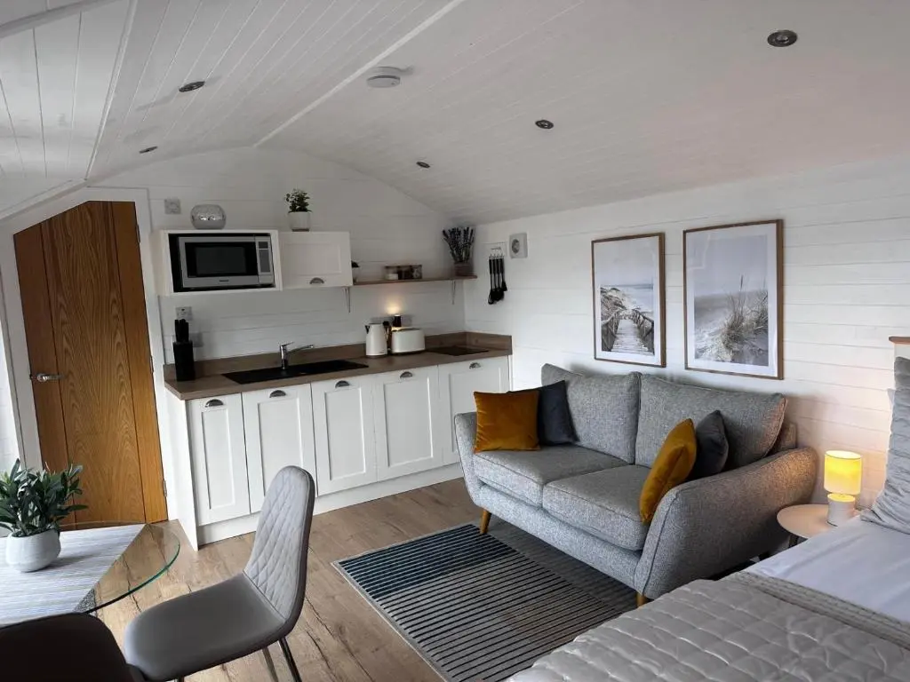 a living room with a couch and a kitchen at Gamrie Beach Bothy in Gardenstown