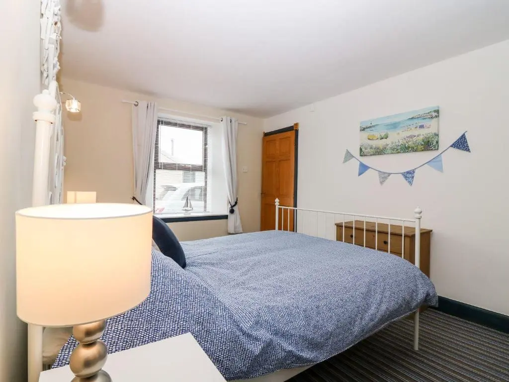 a bedroom with a bed with a blue blanket at Lobster Pot in Banff