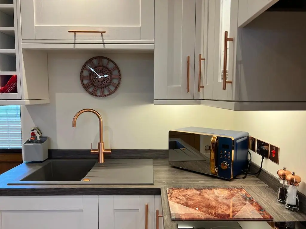 a kitchen with a sink and a microwave at Dalchalm Hideaway in Brora