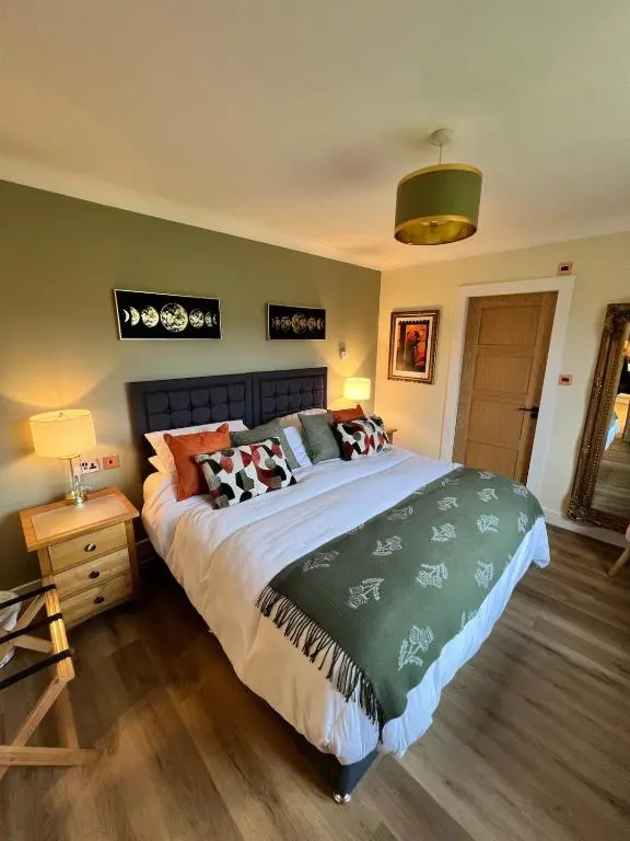 a bedroom with a large bed with pillows on it at Dalchalm Hideaway in Brora