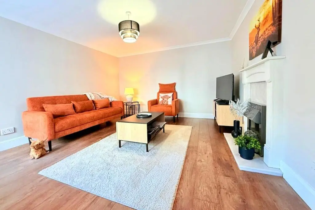 a living room with a couch and a tv at Sea Breeze Cottage short walk to the beach, Nairn in Nairn