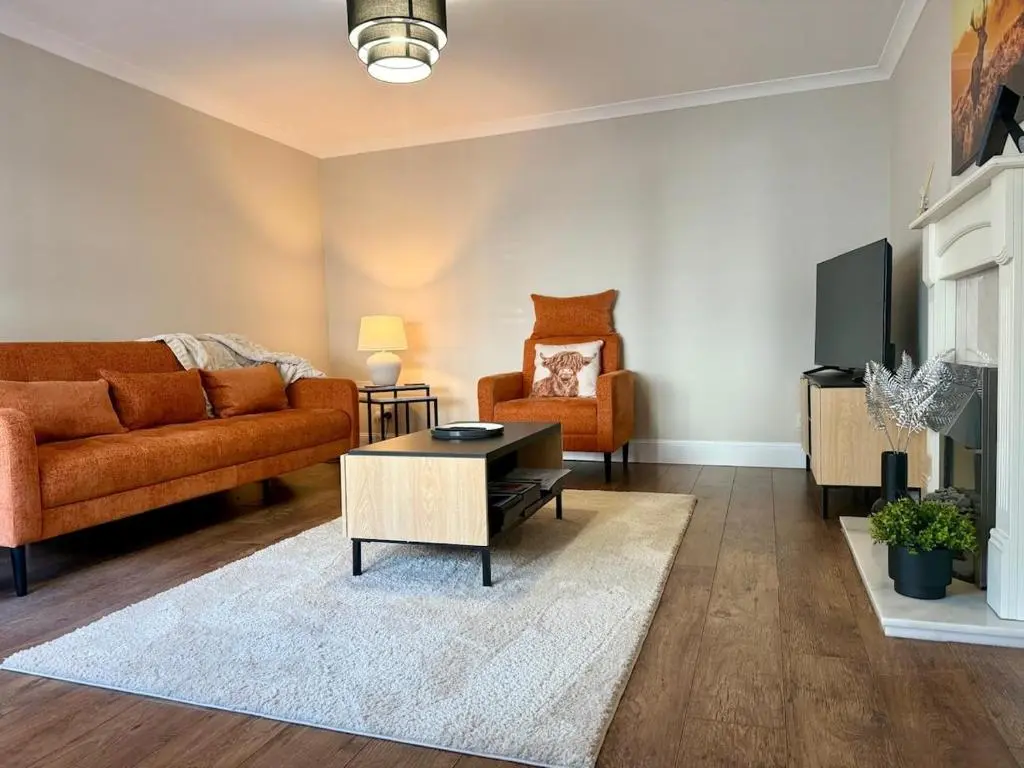a living room with a couch and a table at Sea Breeze Cottage short walk to the beach, Nairn in Nairn