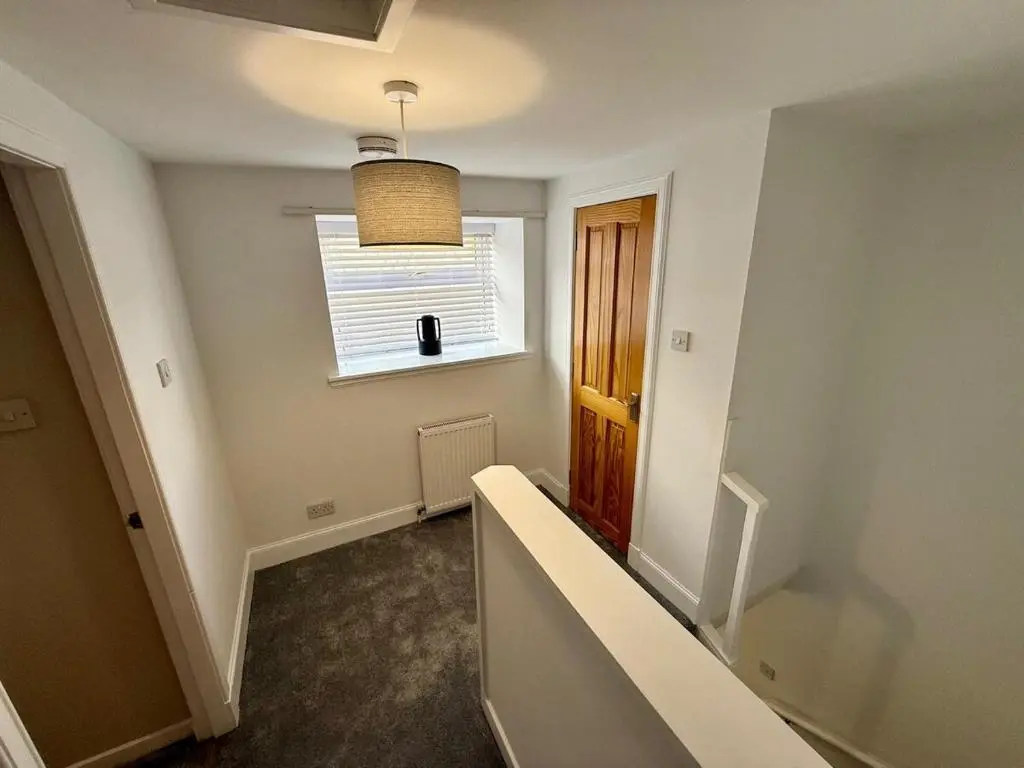 an empty hallway with a window and a stair case at Sea Breeze Cottage short walk to the beach, Nairn in Nairn