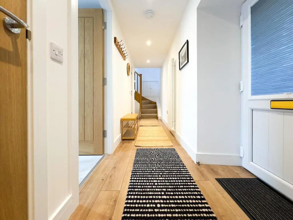 a hallway with a black and white rug on the floor at The Lookout, Lossiemouth in Lossiemouth