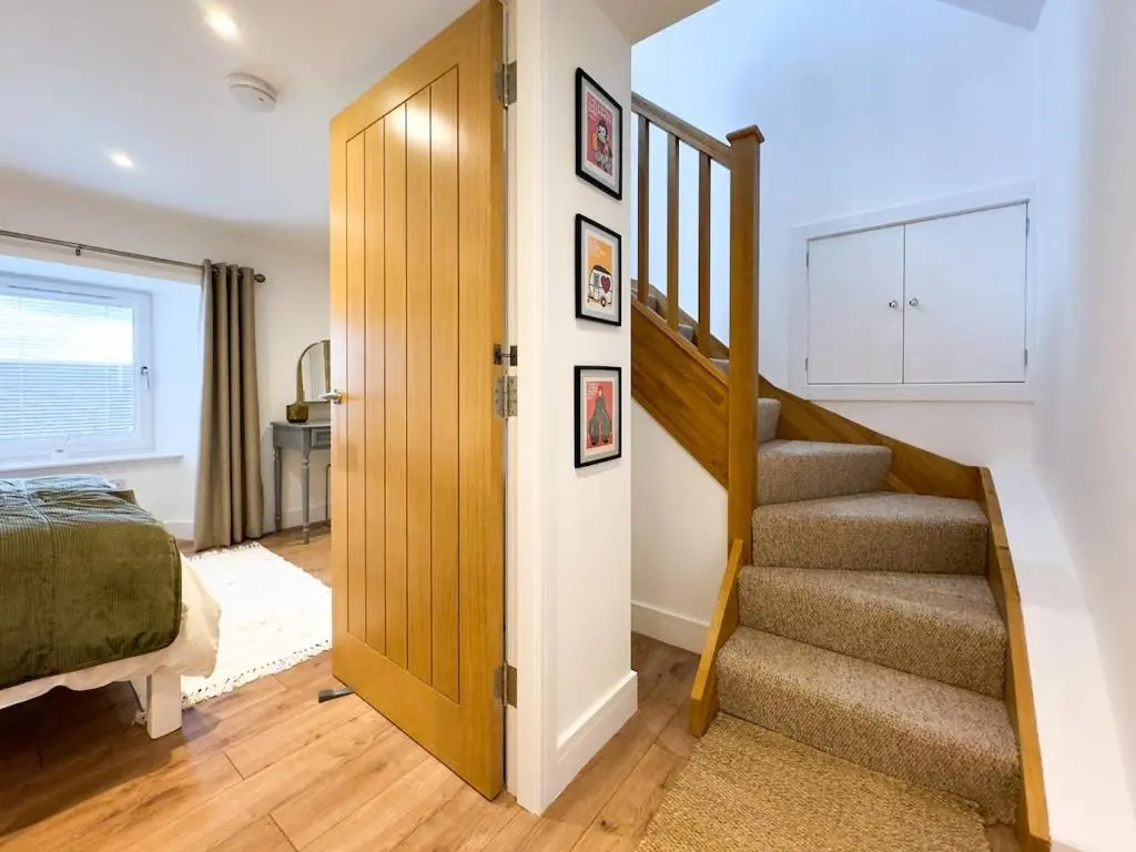 a bedroom with a staircase and a bed and a door at The Lookout, Lossiemouth in Lossiemouth