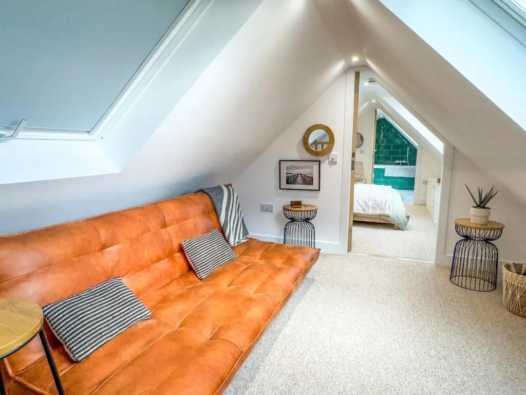 a living room with a couch in a attic at The Lookout, Lossiemouth in Lossiemouth
