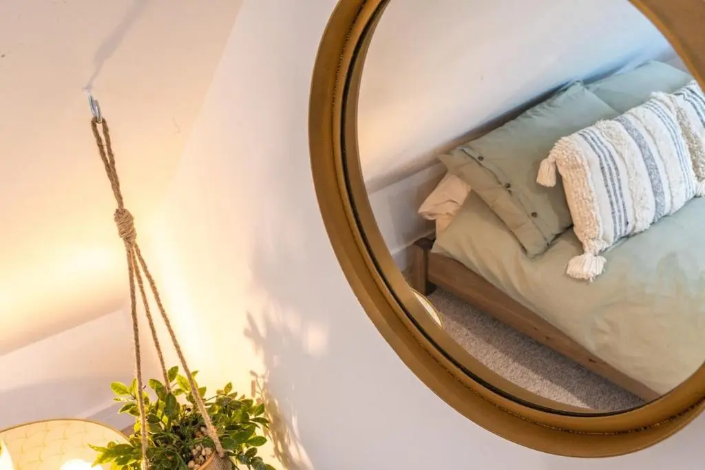 a mirror in a room with a bed and a pillow at The Lookout, Lossiemouth in Lossiemouth