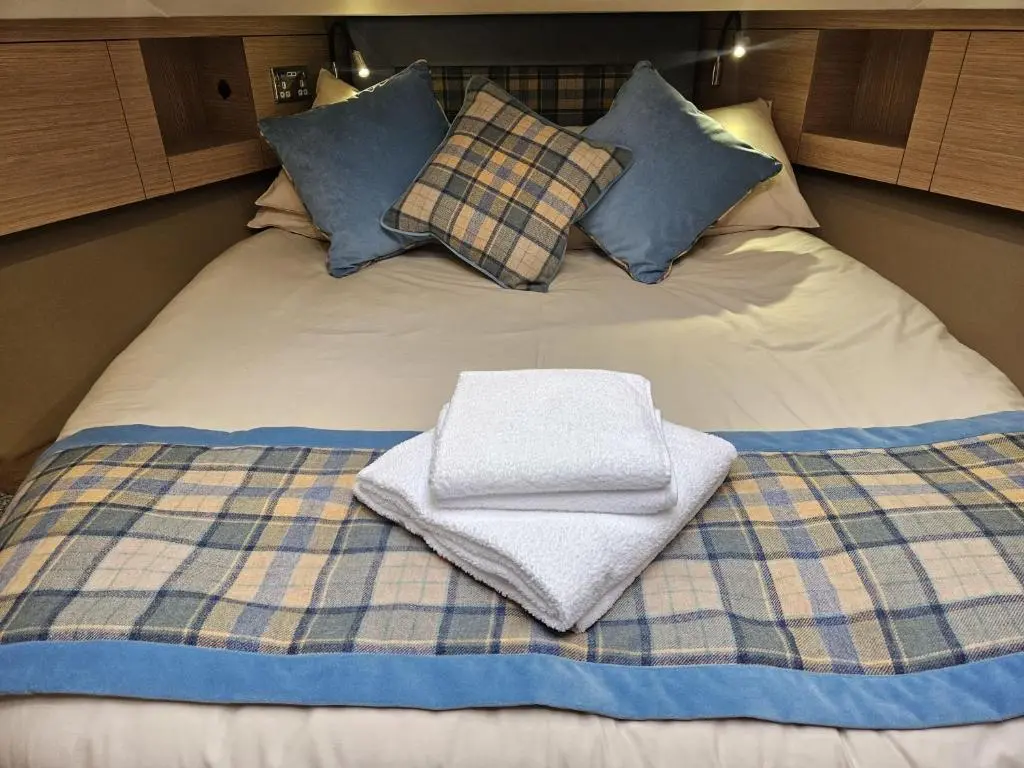 a bed with two towels sitting on top of it at Islay Class 2 in Inverness