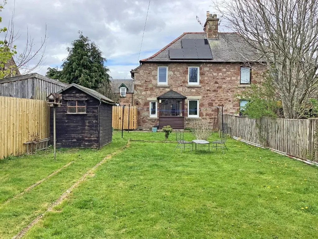 a yard with a brick house with a fence at Seasgair in Dingwall