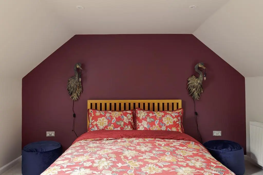 a bedroom with a bed with a red wall at Elrick Estate - Coach House in Newmachar