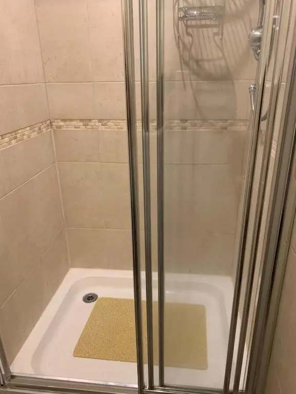 a shower with a glass door next to a tub at Inchmarlo Villa 29 Banchory in Inchmarlo