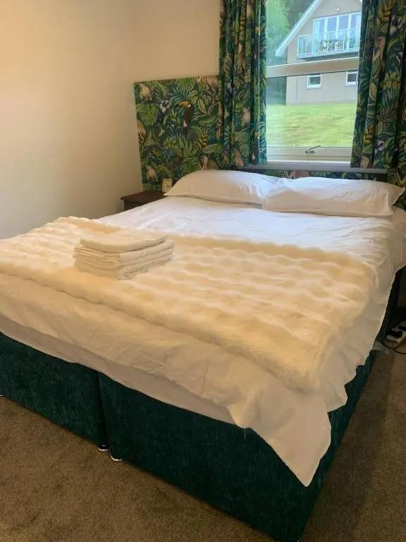 a bed in a bedroom with a window at Inchmarlo Villa 29 Banchory in Inchmarlo