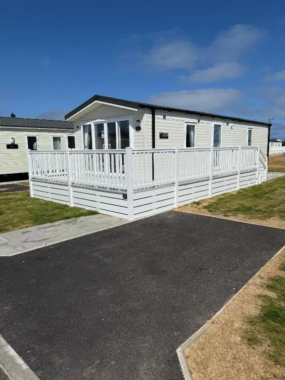 a white mobile home with a porch and a driveway at 36 Lighthouse View in Lossiemouth