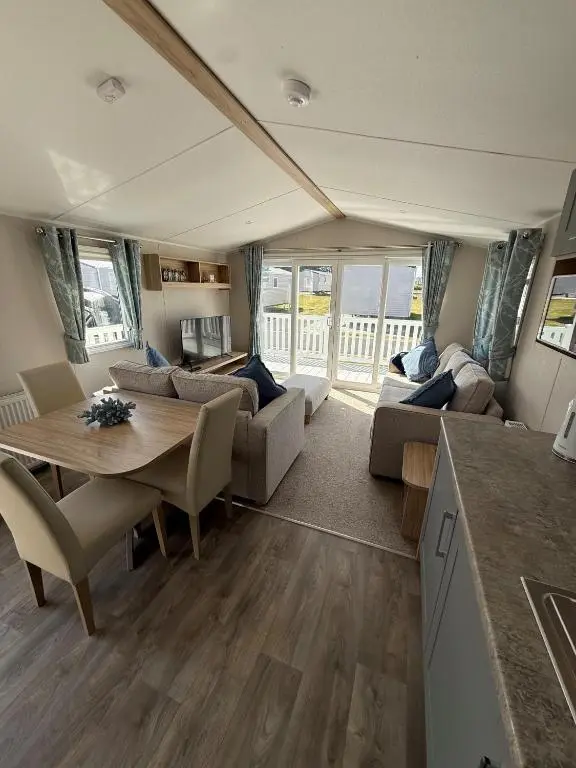 a living room with a table and a couch at 36 Lighthouse View in Lossiemouth