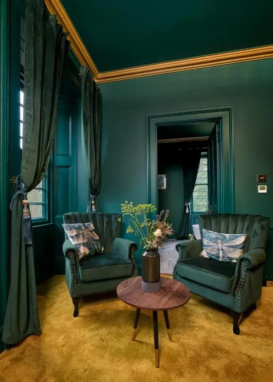 a living room with two chairs and a table at Old Manse of Craggan in Glenlivet