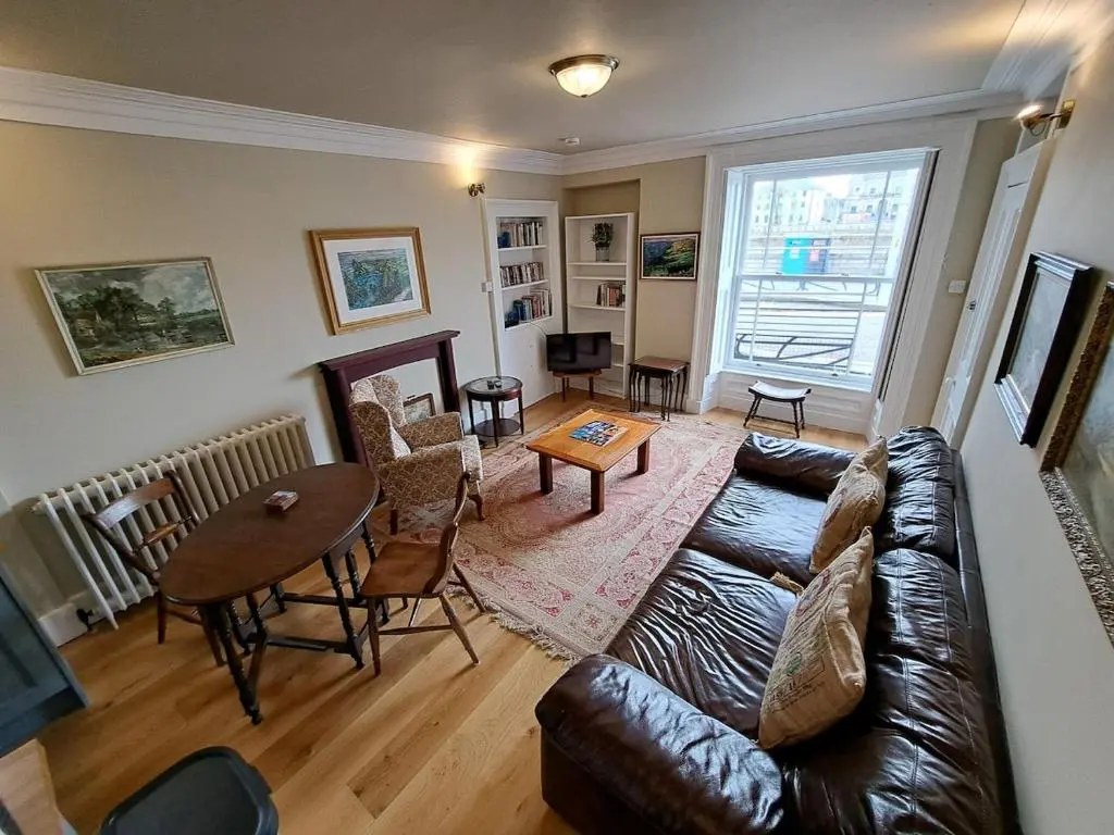 a living room with a couch and a table at Cosy Riverside Apartment with free parking in Inverness