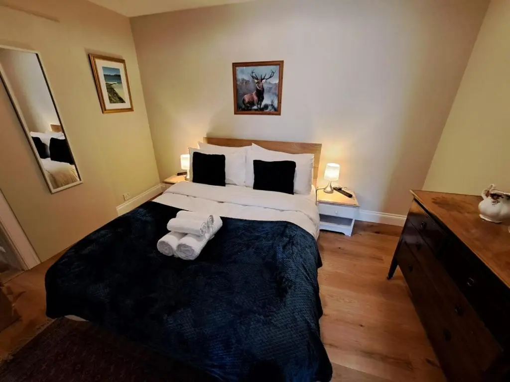 a bedroom with a large bed with towels on it at Cosy Riverside Apartment with free parking in Inverness