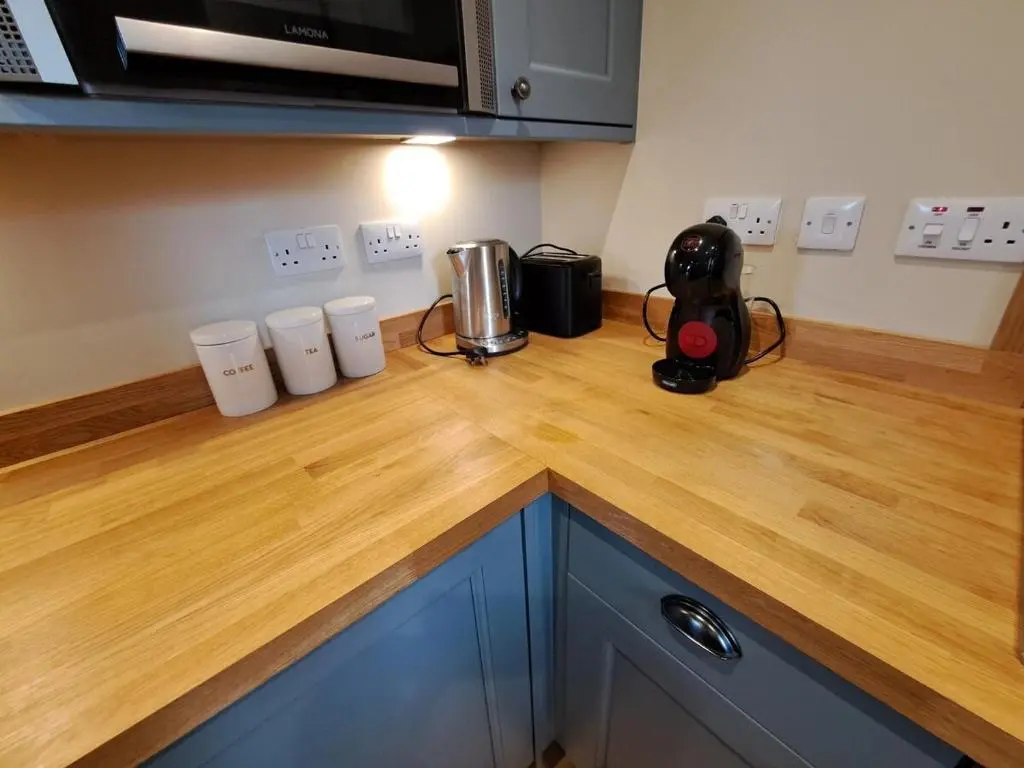 a kitchen counter with a wooden counter top at Cosy Riverside Apartment with free parking in Inverness