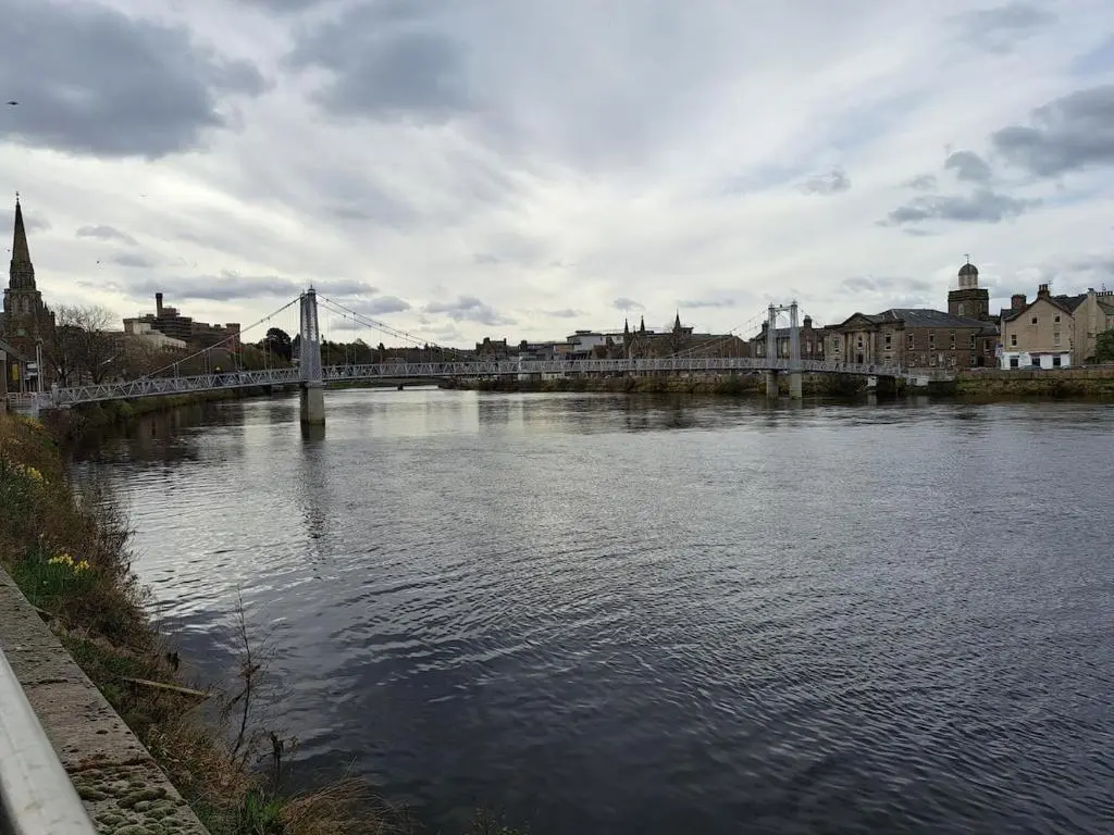 a river with a bridge in a city at Cosy Riverside Apartment with free parking in Inverness