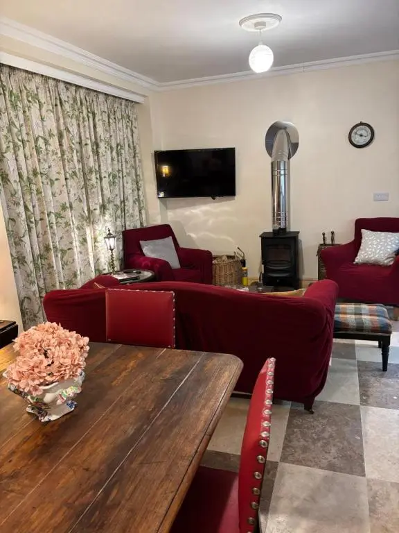 a living room with a couch and a table at Garden Cottage in Cambus O\u02bcMay Station
