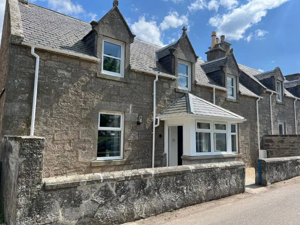 an old stone house on the side of a street at 2 Links Place in Nairn