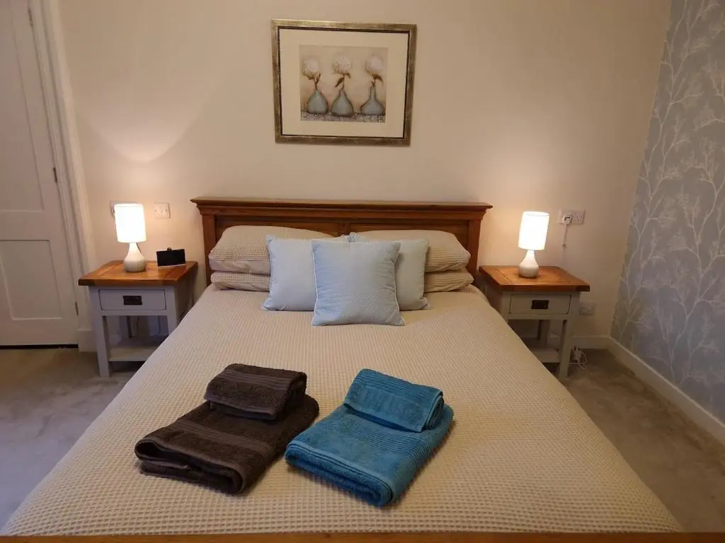 a bedroom with a bed with towels on it at Spacious cosy welcoming cottage in Ballater