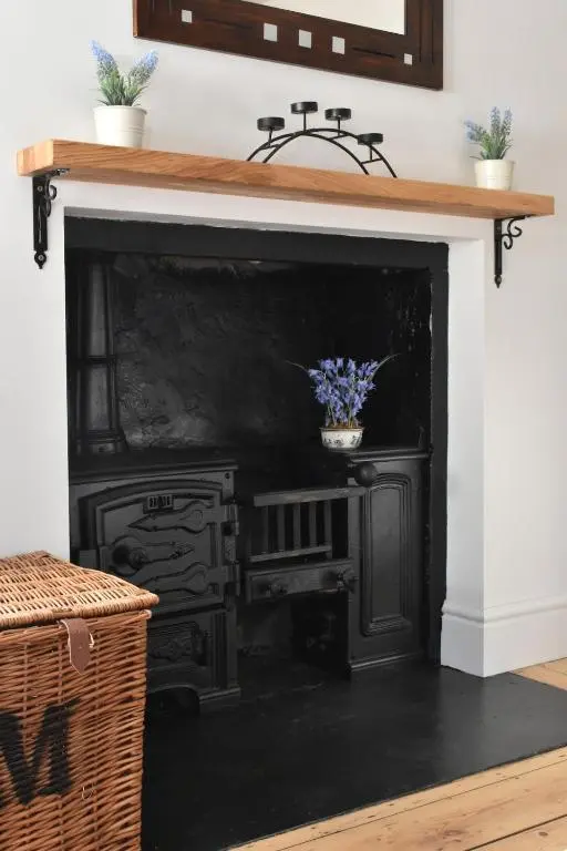 an old black fireplace with a potted plant on it at The MacKenzie Apartment in Beauly