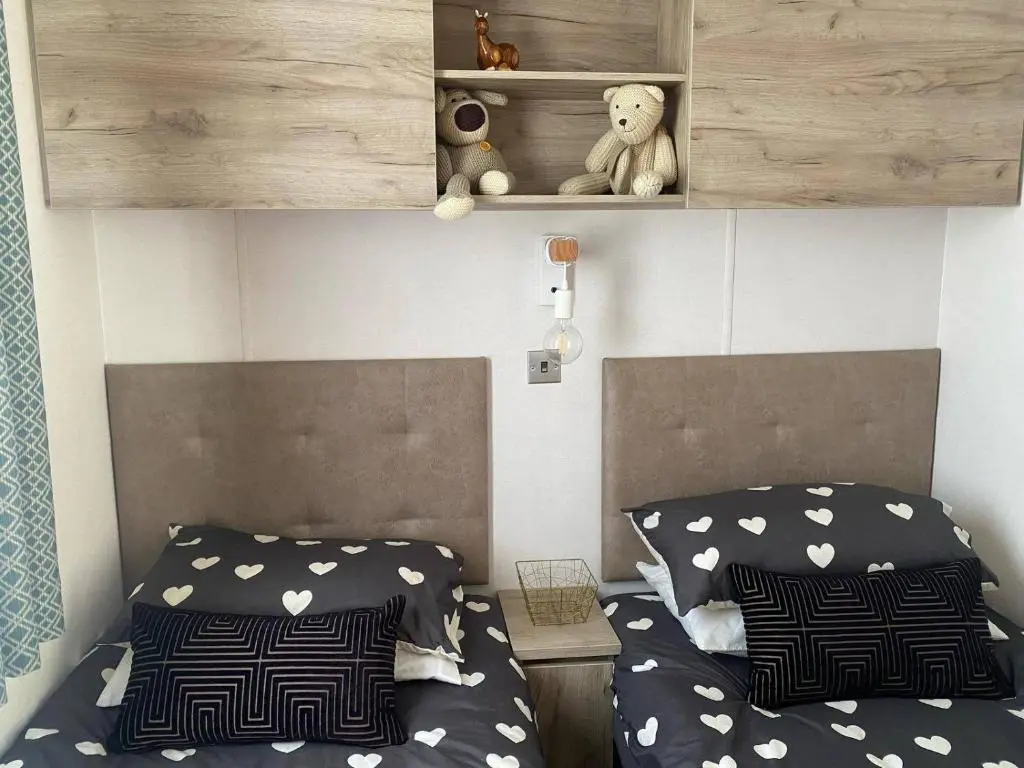 a bedroom with two beds and a teddy bear on a shelf at Findhorn Lodge - Peaceful - Pets - Sleeps 4 in Forres