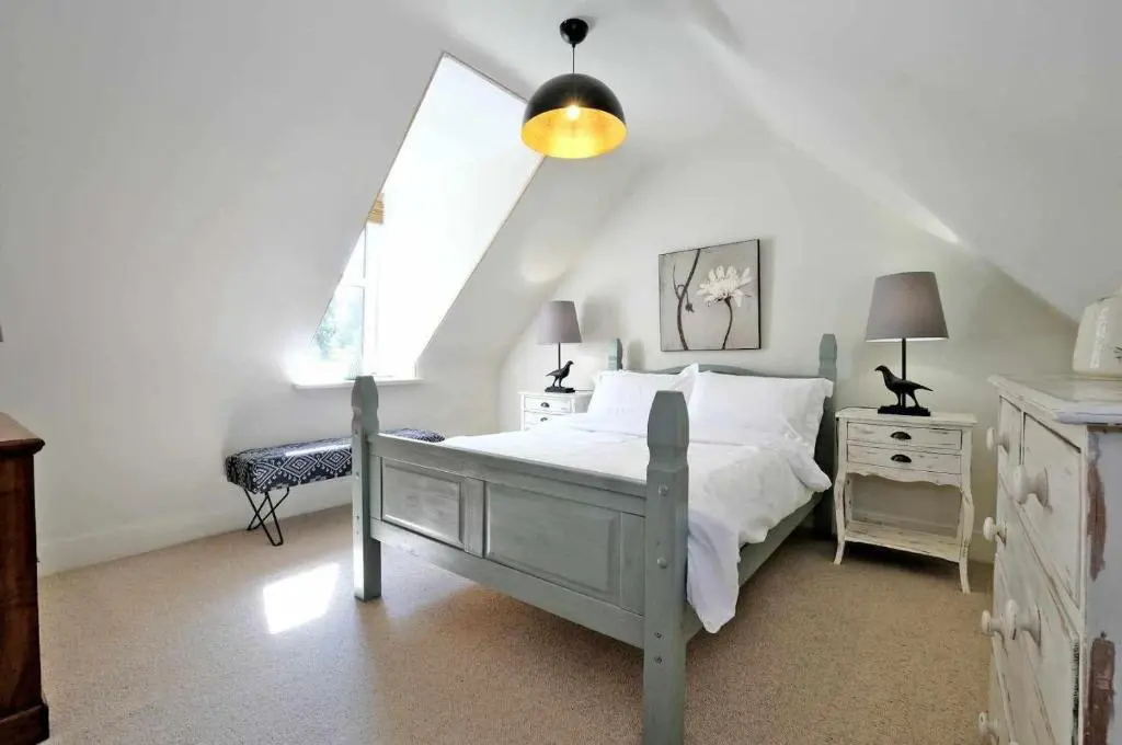 a bedroom with a white bed and a window at West Manse in Inverurie