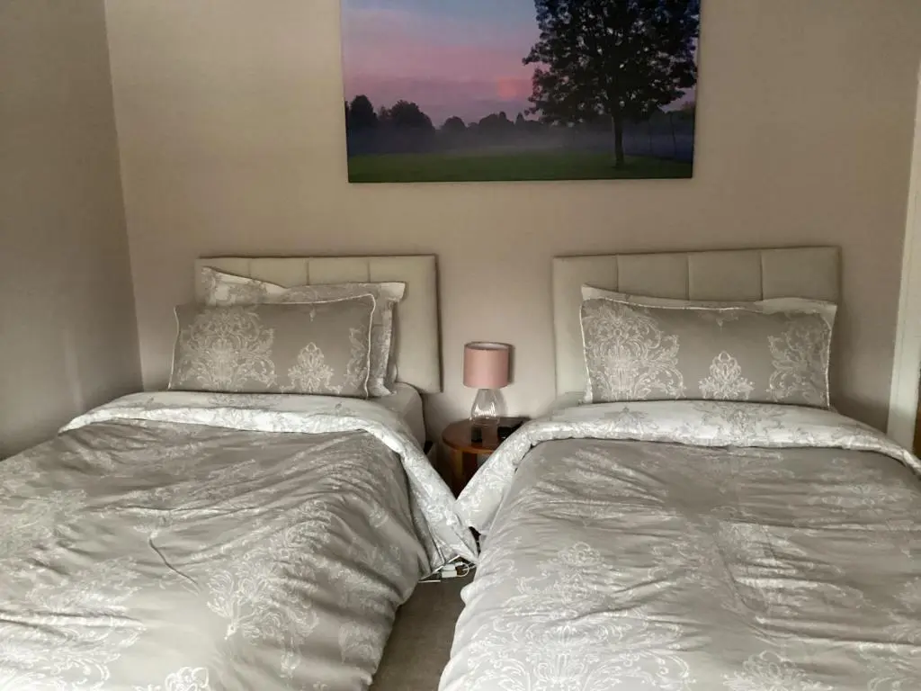 two beds sitting next to each other in a bedroom at Charlies in Huntly