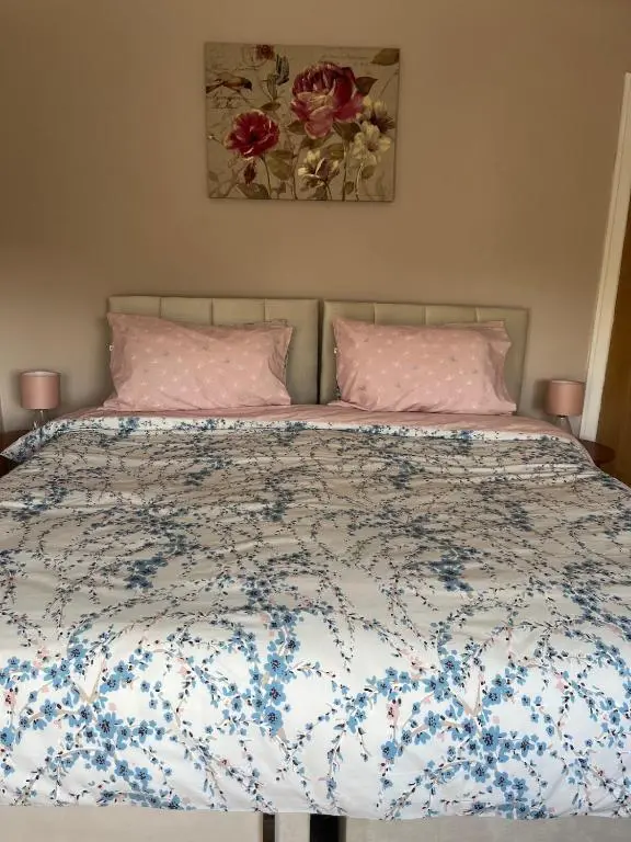 a bedroom with a bed with pink and blue flowers at Charlies in Huntly