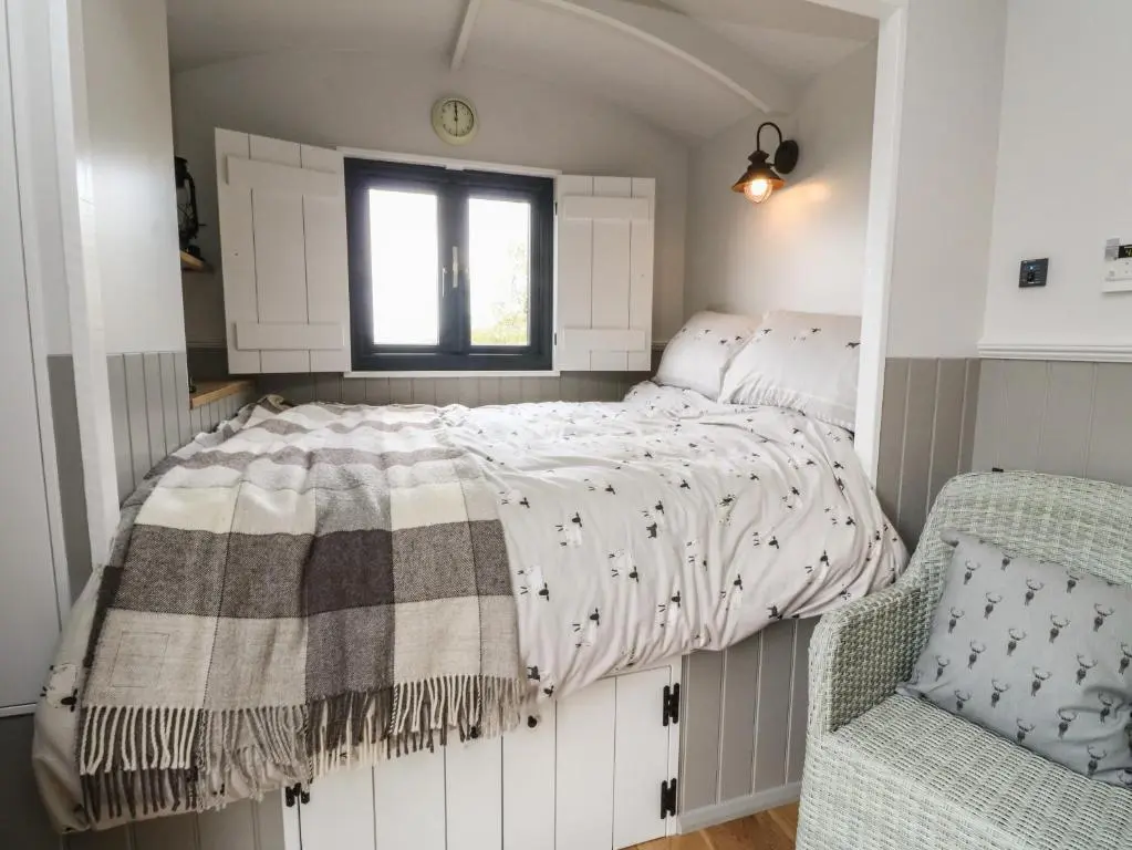 a small bedroom with a bed and a window at Coraldie in Newtonmore