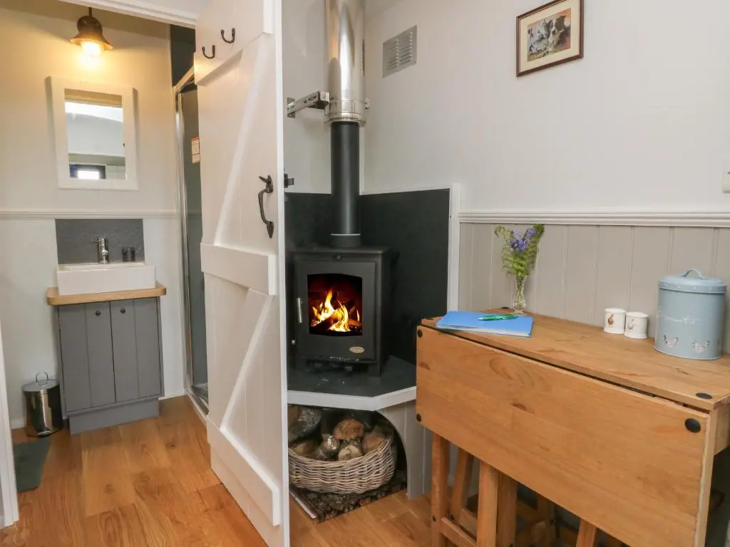 a kitchen with a wood stove in a room at Coraldie in Newtonmore