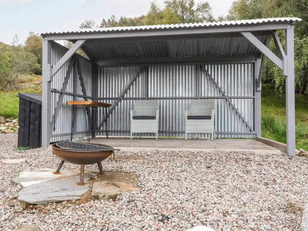 a metal pavilion with two chairs and a table at Coraldie in Newtonmore