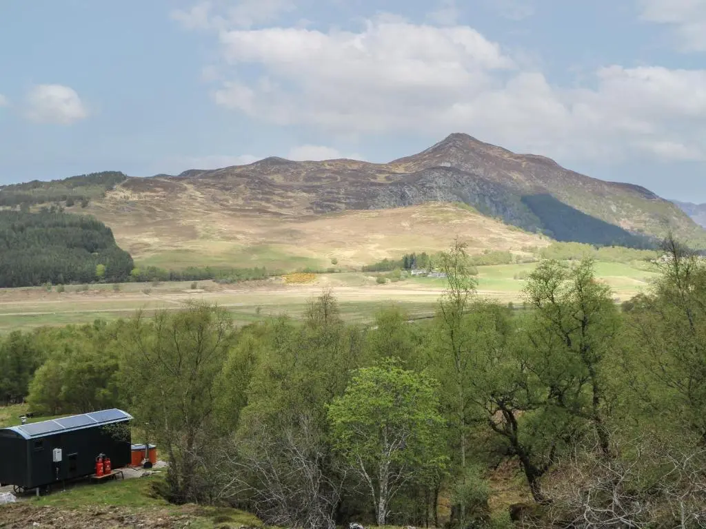 a black truck parked in front of a mountain at Coraldie in Newtonmore