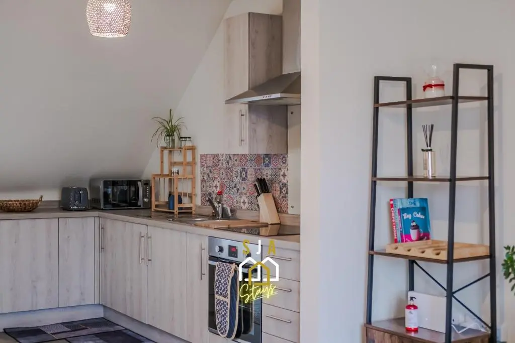a kitchen with white cabinets and a stove top oven at Ballater Retreat - SJA Stays - Modern 1 Bed Apartment in Ballater