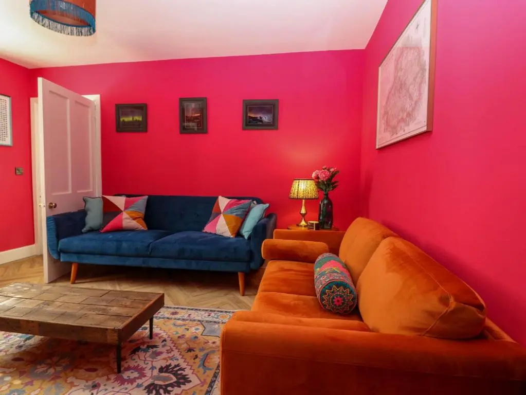 a living room with a couch and pink walls at Evansford in Ballater
