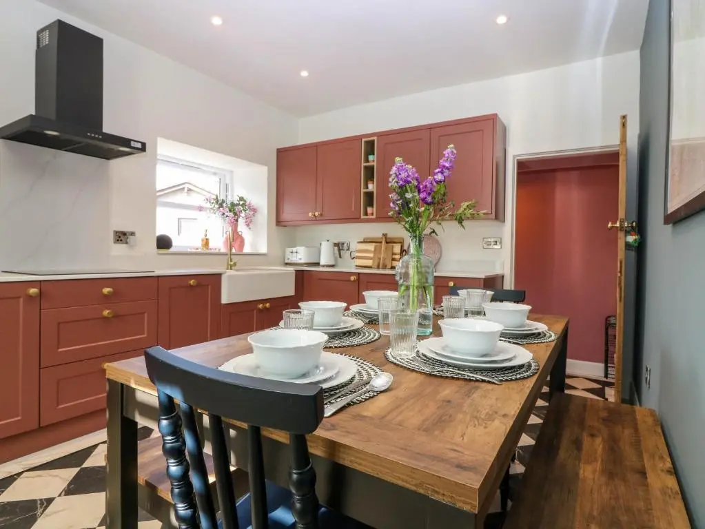 a kitchen with a wooden table with a vase of flowers at Evansford in Ballater