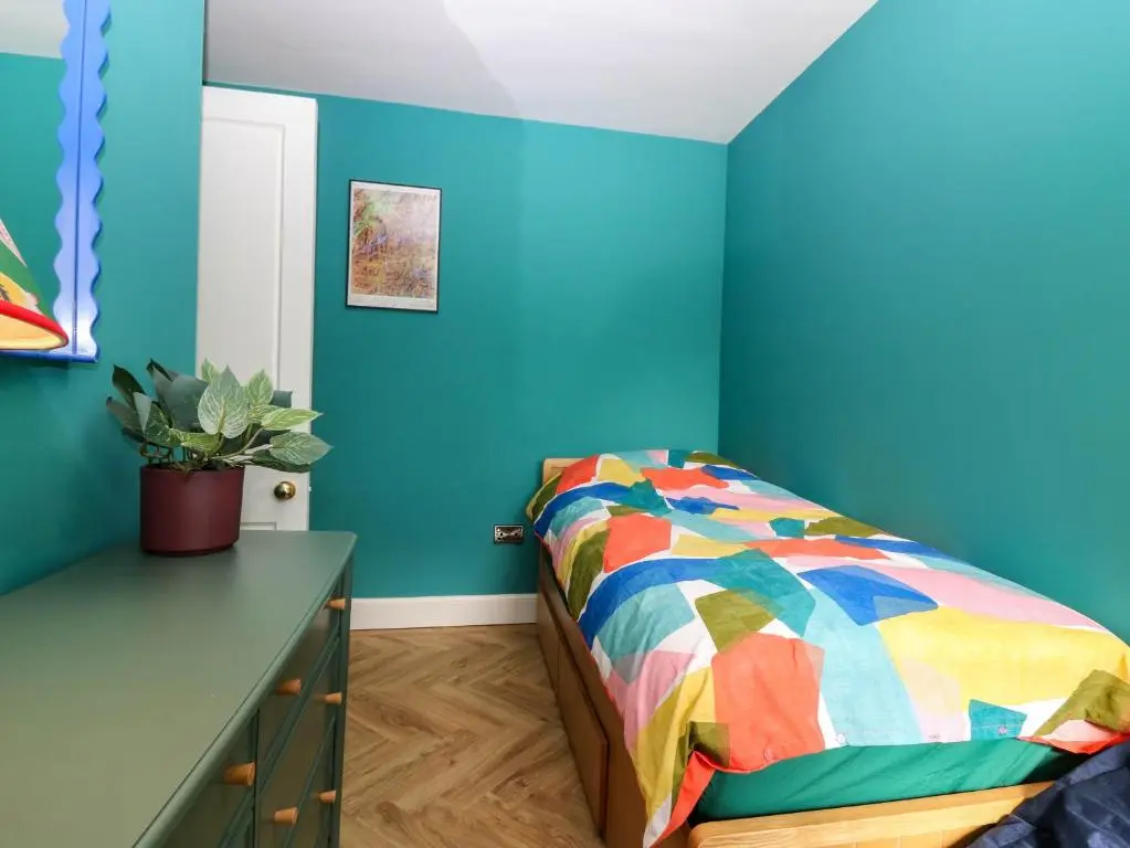 a bedroom with a bed and a blue wall at Evansford in Ballater