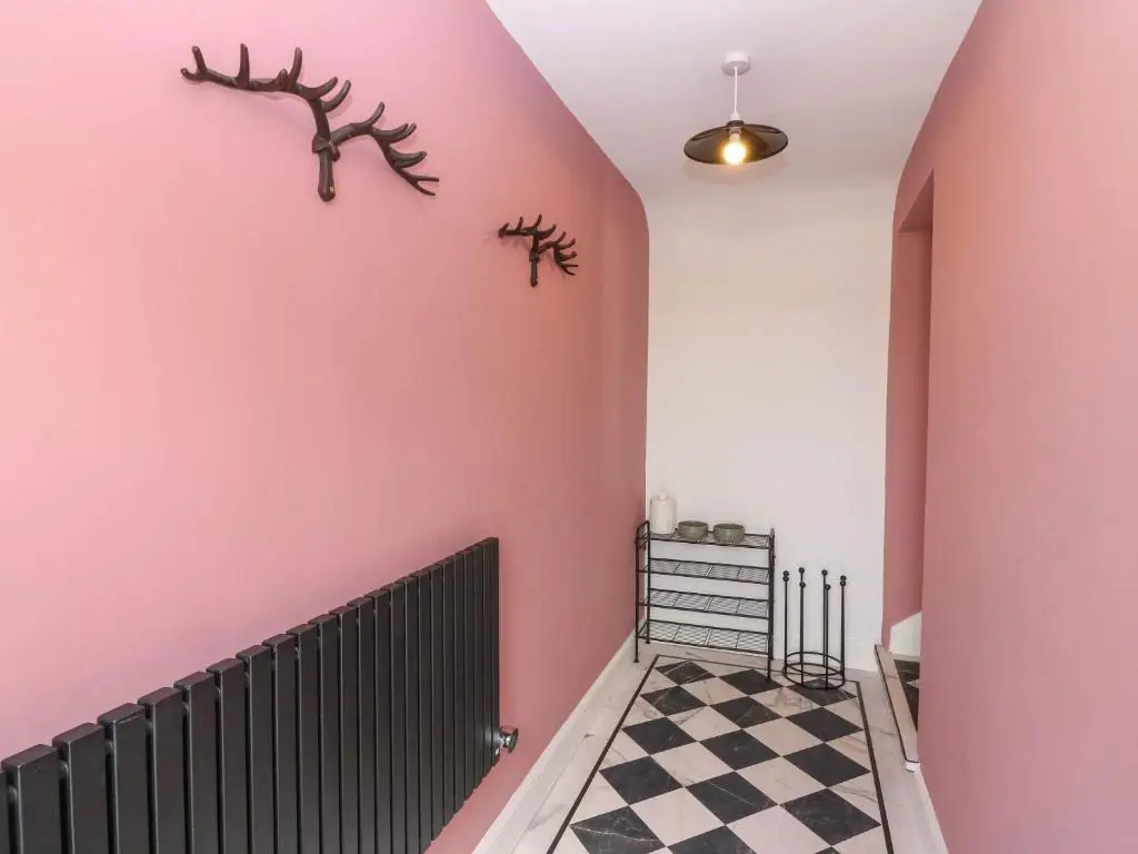 a hallway with pink walls and a checkered floor at Evansford in Ballater