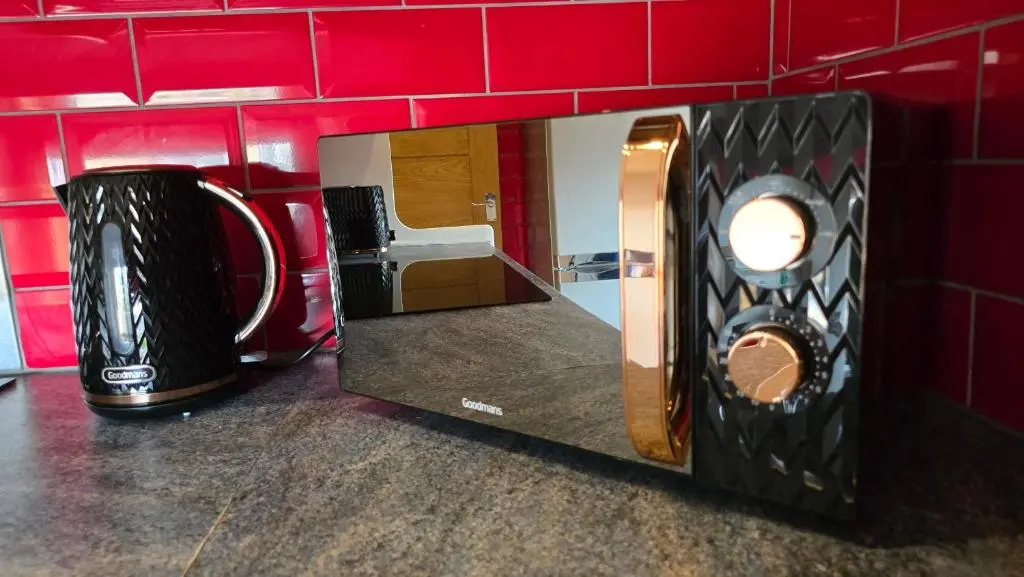 a microwave in a red room with two microwaves at Stylish 1-Bed City Centre Flat in Inverness