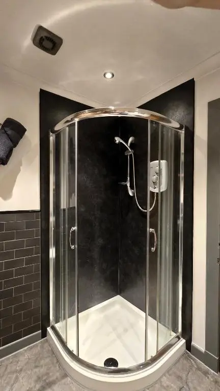 a shower with a glass enclosure in a bathroom at Stylish 1-Bed City Centre Flat in Inverness