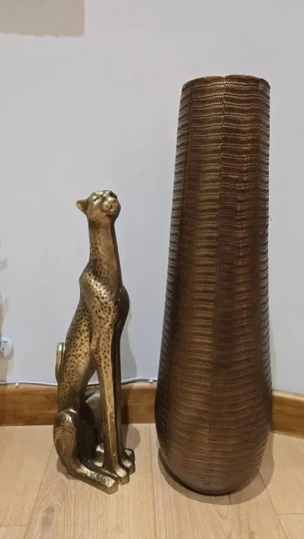 a figurine of a cat sitting next to a vase at Stylish 1-Bed City Centre Flat in Inverness