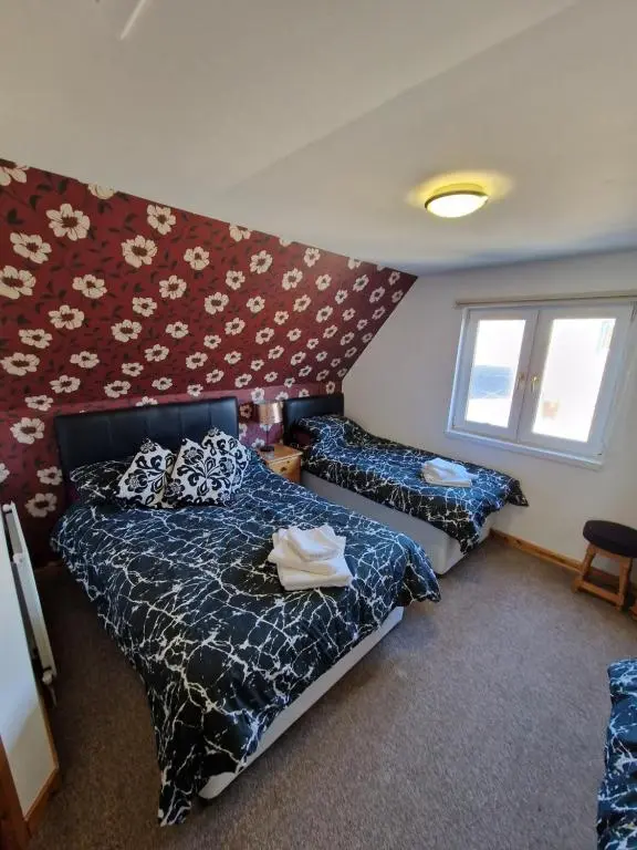 a bedroom with two beds and a window at The harbour inn in Burghead